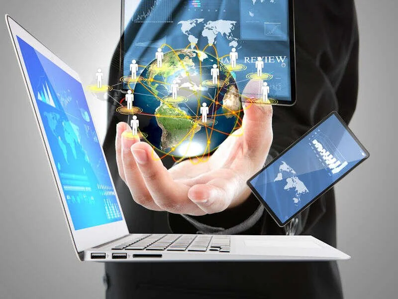 Globe numérique tenu au-dessus d'un ordinateur portable